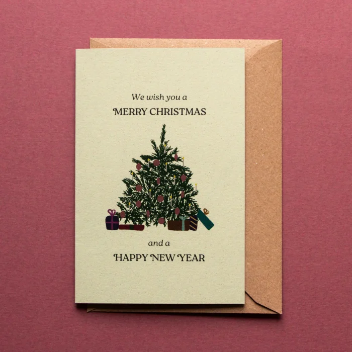 Kerstkaart Onder de kerstboom met illustratie van een kerstboom met kaarsjes en rode kerstornamenten erin en pakjes onder de boom. De tekst luidt: we wish you a merry christmas and a magical new year.