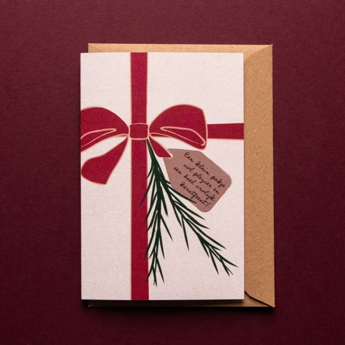 Kerstkaart Een pakje voor kerst met illustratie van een grote strik omheen het kaartje, het lijkt alsof het kaartje zelf is ingepakt als cadeau. Er zitten twee dennentakjes bij tussen de strik en er hangt een kaartje aan met de tekst: Een klein pakje vol plezier en een heel vrolijk kerstfeest!