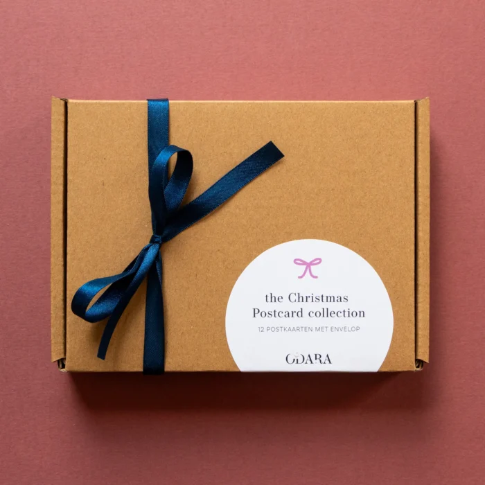 Kaartenset The Christmas Postcard Collection verpakt in een kartonnen doosje met satijnen strik eromheen.