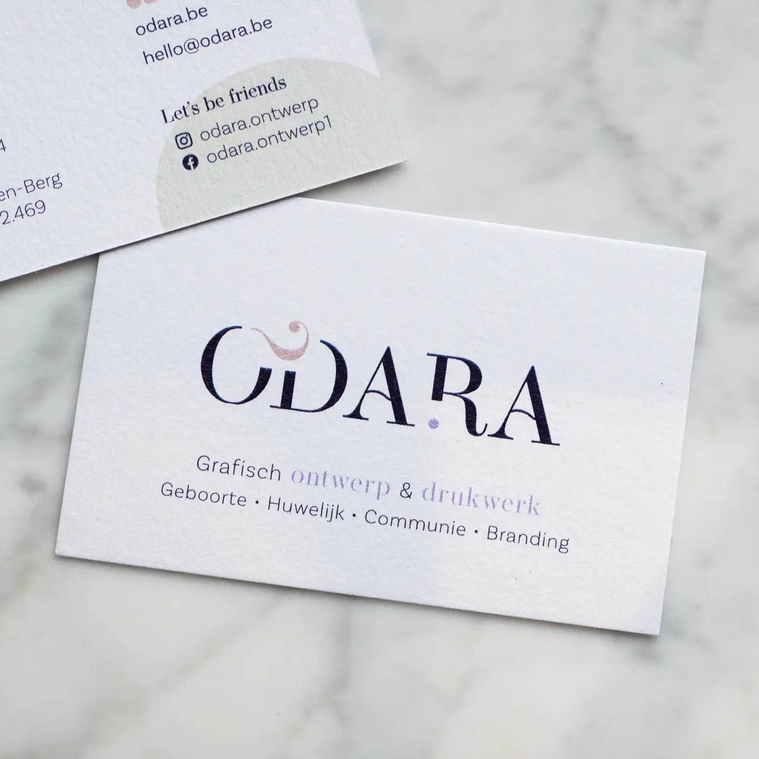 Visitekaartje van ODARA, met de tekst: grafisch ontwerp en drukwerk, voor geboorte, huwelijk, communie en branding.