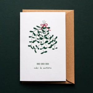 Kerstkaart Onder de mistletoe met illustratie van een zwevende bos maretakken samengebonden met een strik en de tekst: HO HO HO onder de mistletoe.