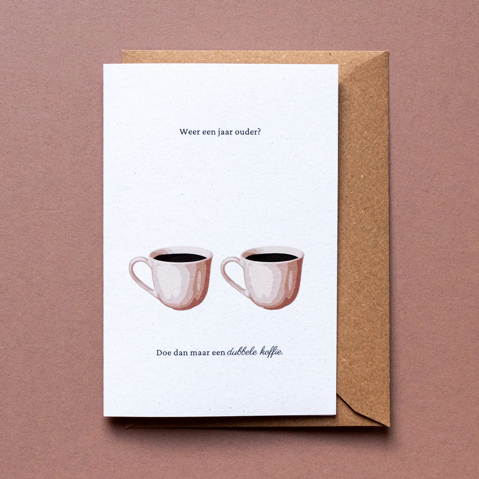 Verjaardagskaart dubbele koffie met illustratie van twee tassen met zwarte koffie erin en de tekst: 'Weer een jaar ouder? Doe dan maar een dubbele koffie.'